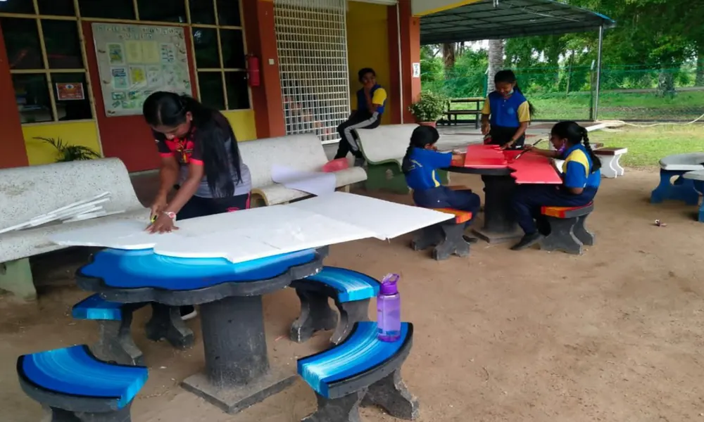 Pupils working together at outdoor tables in the school grounds