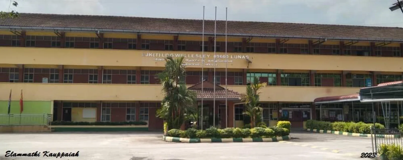 The three-storey main building of SJK(T) Ladang Wellesley with its flagpoles and entrance porch